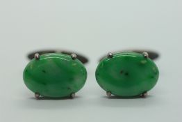 A PAIR OF JADE CUFF LINKS IN WHITE METAL SETTINGS.