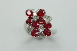 A RUBY AND DIAMOND CROSS OVER RING OF BOW DESIGN,