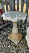 A LARGE STONEWORK GARDEN BIRD BATH,THE BASE OF BALUSTER FORM WITH SCROLL DECORATION HEIGHT 65CM.