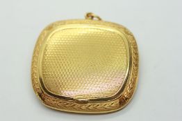 A YELLOW METAL PENDANT PILL BOX WITH ENGINE TURNED FINISH INDISTINCT MARK.