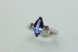 AN 18CT GOLD RING, THE CENTRAL BLUE NAVETTE CUT STONE FLANKED BY TWO BRILLIANT DIAMONDS.