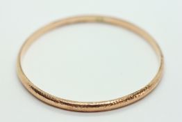 A HOLLOW 9CT GOLD BANGLE.