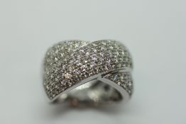 AN 18CT WHITE GOLD CROSS OVER RING SET WITH VERY SMALL DIAMONDS.