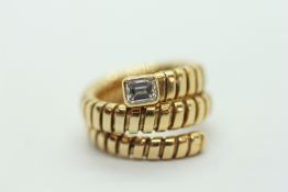 AN 18CT YELLOW GOLD ARTICULATED RING SET WITH SINGLE BAGUETTE DIAMOND.