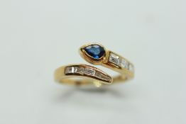 AN 18CT YELLOW GOLD RING OF SNAKE DESIGN, THE HEAD SET WITH A TEARDROP SAPPHIRE,