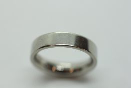 A WHITE METAL WEDDING BAND, ASSUMED PLATINUM.