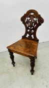 AN ANTIQUE OAK HALL CHAIR WITH CARVED BACK.