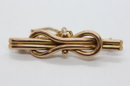 A VINTAGE 15CT GOLD BROOCH WITH SAFETY CHAIN.