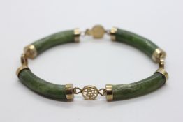A VINTAGE ORIENTAL GOLD TONE BRACELET WITH JADE PANELS.
