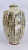 JIM MALONE: A FACETED STONEWARE OVOID VASE WITH GREY GLAZE, HEIGHT 30CM, IMPRESSED MARK.