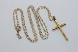 A 9CT GOLD CROSS PENDANT SUSPENDED ON A FINE 9CT GOLD CHAIN. L 50CM.
