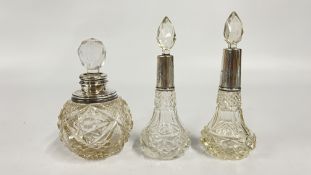 A GROUP OF THREE VINTAGE CUT GLASS PERFUME DECANTERS WITH SILVER MOUNTS AND STOPPERS.
