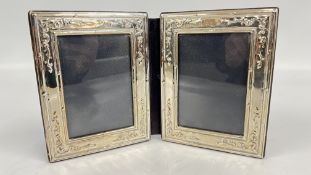 A HINGED SILVER DOUBLE PHOTOGRAPH FRAME WITH EMBOSSED DECORATION BIRMINGHAM ASSAY 1985 MAKER PJP,