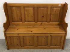 A HONEY PINE PEW BENCH WITH HINGED SEAT.
