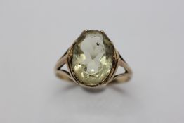 A 9CT GOLD RING SET WITH A PALE GREEN OVAL TOPAZ.