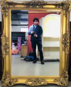 A LARGE REPRODUCTION GILT FRAMED MIRROR WITH BEVELLED PLATE GLASS 153 X 122CM.