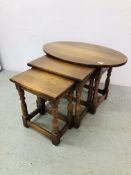 A NEST OF 3 OAK TABLES, THE LARGEST WITH OVAL TOP.