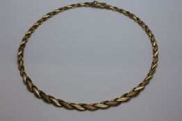 A 9CT GOLD NECKLET WITH ALTERNATING BRUSHED AND POLISHED LINKS.