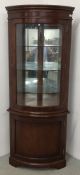 A GOOD QUALITY REPRODUCTION HALF GLAZED CORNER CABINET BEARING LABEL ERIC BATES.