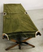 A VINTAGE GREEN MILITARY FOLDING BED.