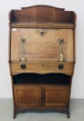 AN OAK ARTS AND CRAFTS STYLE WRITING BUREAU WITH CUPBOARD TO BASE, W 68CM, D 35CM, H 128CM.