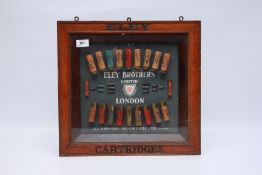 A VINTAGE ELEY BROTHERS LIMITED LONDON MOUNTED CARTRIDGE DISPLAY IN A GLAZED OAK FRAME EMBOSSED