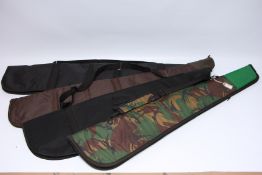 A GROUP OF FOUR VARIOUS GUN SLIPS INCLUDING BLACK CANVAS, CAMO CANVAS,