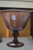 A large amethyst glass pedestal bowl.