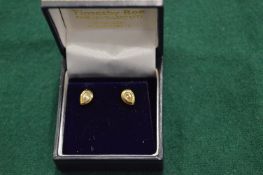A pair of gold and diamond pear shaped ear studs.