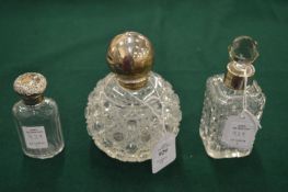 Three silver mounted cut glass scent bottles.