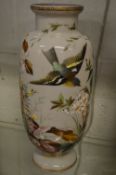 An opaque glass vase painted with a bird and flowers.