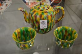 A Chinese teapot with mottled glazed decoration with a pair of matching tea bowls.