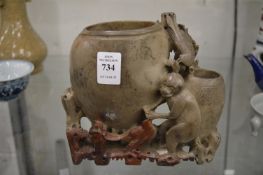 A Chinese carved soap stone vase depicting monkeys and birds.
