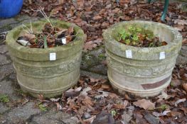A pair of reconstituted stone planters.