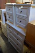 A pair of white painted laminate two drawer bedside chests with matching chest of drawers.