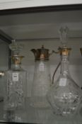 Two silver mounted cut glass decanters and a cut glass claret jug with plated mounts.