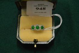 A gold, diamond and jade set three stone ring.