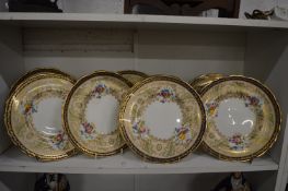 A set of eight Cauldon china cabinet plates with floral decoration and blue and gilt borders.