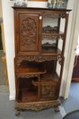 A late 19th century carved hardwood display cabinet with two decoratively carved panel doors, a