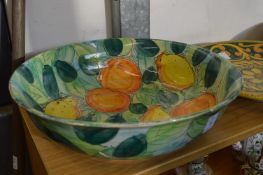 Large colourful fruit bowl and three pottery chargers.