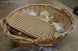 Wicker basket containing curtains and furnishing fabrics.
