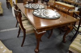 A mahogany rectangular extending dining table with one extra leaf on cabriole legs.