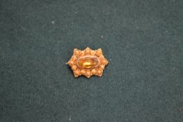 Decorative yellow metal brooch set with a citrine coloured stone.
