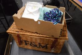 A wicker hamper and various textiles and clothing.
