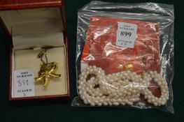 A pearl necklace and a decorative pendant and chain.