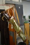 An old golf bag containing two walking sticks and a shooting stick.