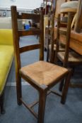 A set of four rush seated beech ladderback dining chairs.