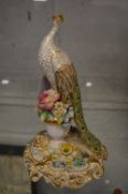 A Derby porcelain group of a peacock with floral encrusted decoration.
