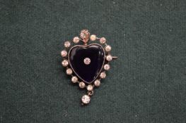 A decorative enamel and paste set heart shaped brooch.