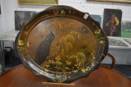 A toleware tray painted with a peacock on a branch.